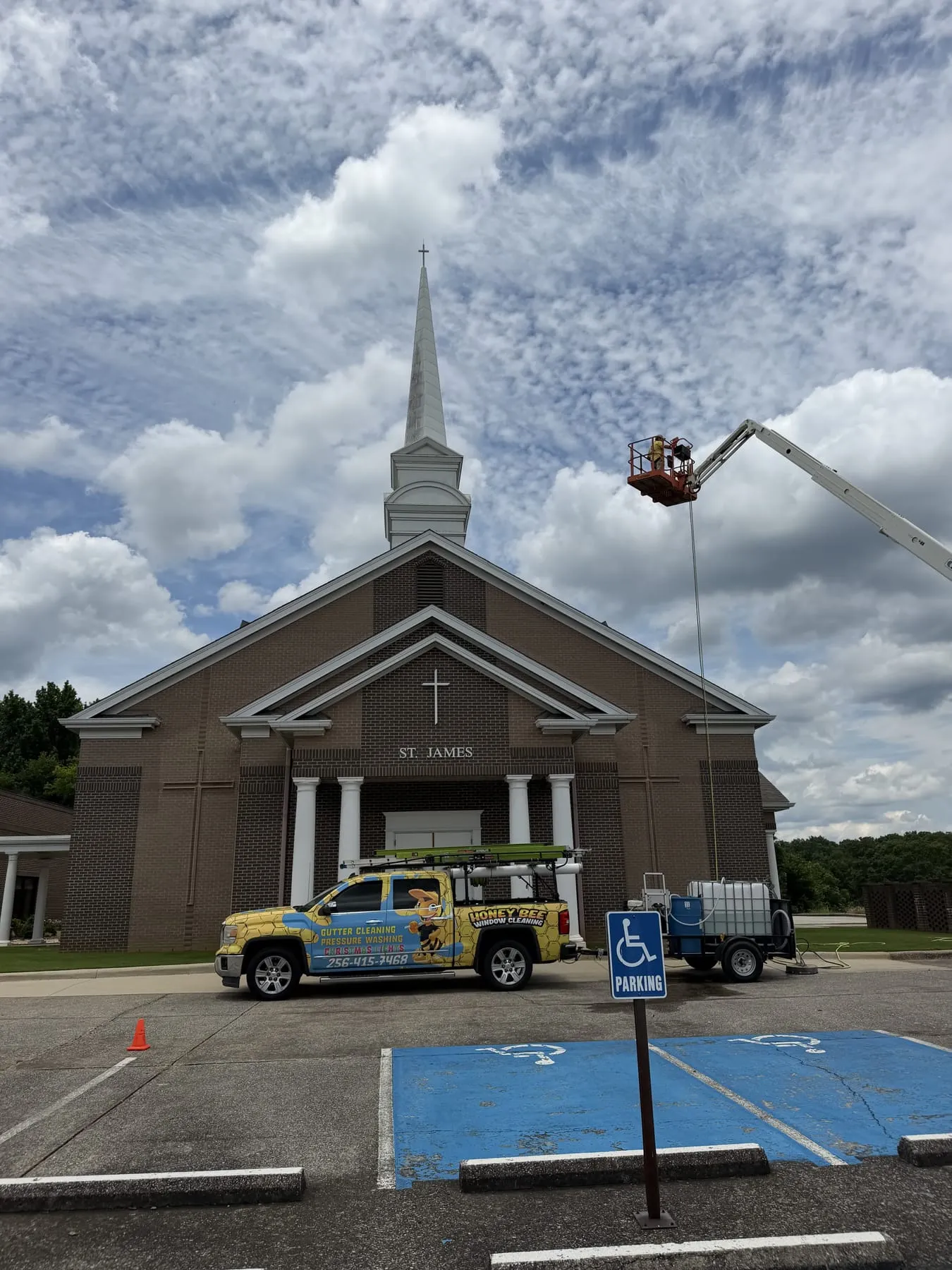 HoneyBee truck and boom lift soft-washing the steeple at St. James church