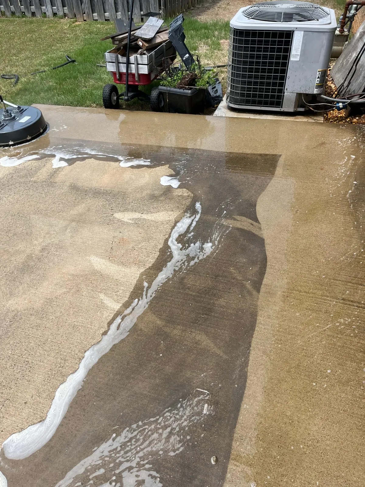 Driveway half-cleaned mid-job, showing the before and after contrast